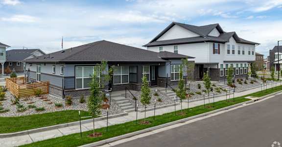 A modern house with a grey roof and a flag on top.