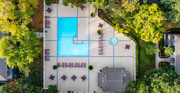 An aerial view of a pool surrounded by trees and a building at Cherrywood Apartments, San Jose, 95118