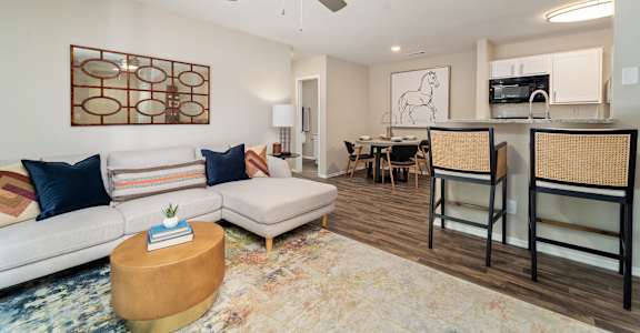 A living room with a white couch and a wooden coffee table.