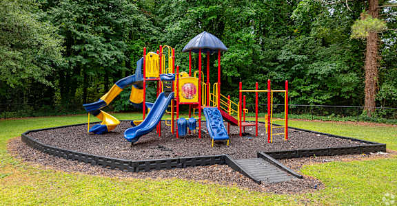 A playground with a yellow slide and a blue slide.