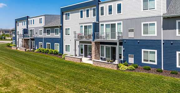 a row of houses with balconies and a green lawn