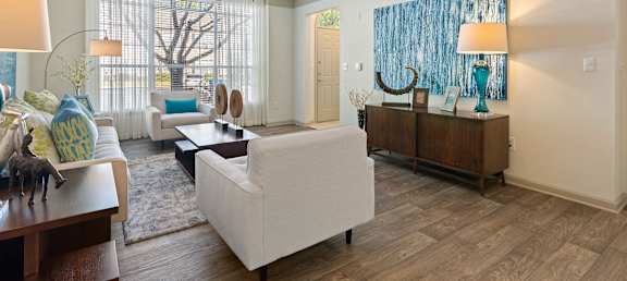 A living room with a white couch and a wooden floor.