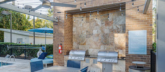 a patio with a table and chairs and a barbecue grill