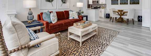 A living room with a red couch and a leopard print rug.