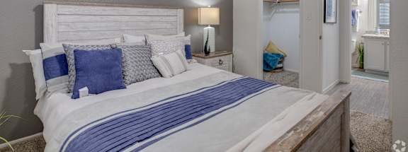 A bedroom with a large bed and a painting on the wall.