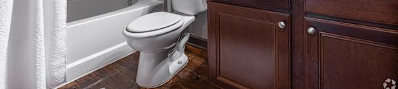 a bathroom with a toilet and a sink and a bath tub at Kingston Crossing Apartment Homes, Bossier City