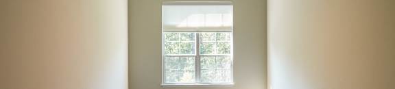 an empty room with a ceiling fan and a window at The Vineyard at Castlewoods Apartment Homes in Brandon, MS