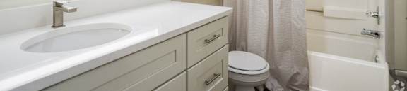 a bathroom with a sink and a toilet and a shower at The Vineyard at Castlewoods Apartment Homes in Brandon, Mississippi