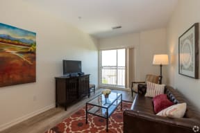 a living room with a couch and a glass coffee table and a television