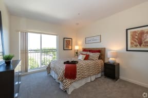 a bedroom with a large bed and a window with juliet balcany