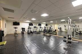 A gym with a variety of exercise equipment.