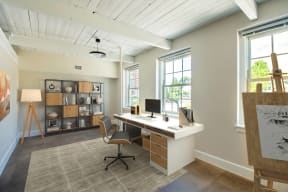 a home office with a desk and a chair and two windows at Beverly Village for Living & the Arts Apartments, Massachusetts, 01915