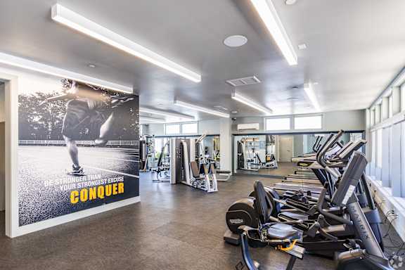 A gym with a poster that says "CONQUER" on it.