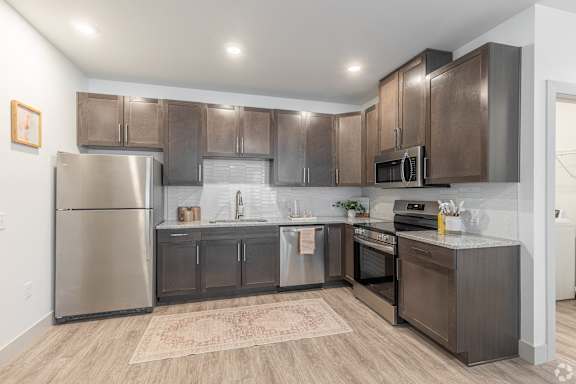 A modern kitchen with stainless steel appliances and wooden cabinets.