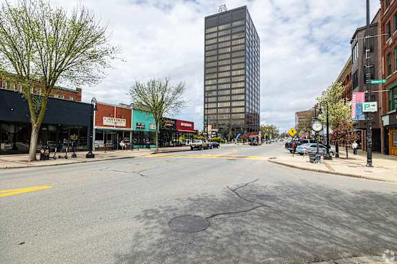 A city street with a tall building in the background.
