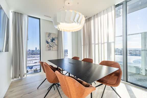 A modern dining room with a large table and chairs.