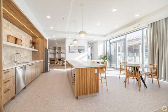 A modern kitchen with wooden cabinets and a dining table.