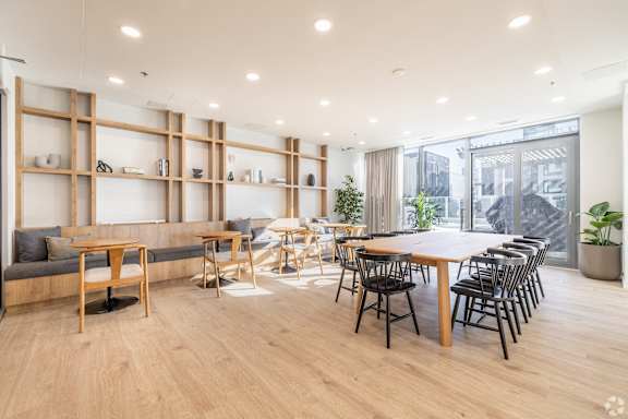 A modern living room with a long wooden table and chairs.