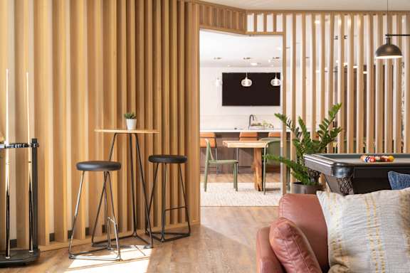 A modern living room with a bar stool and a couch.