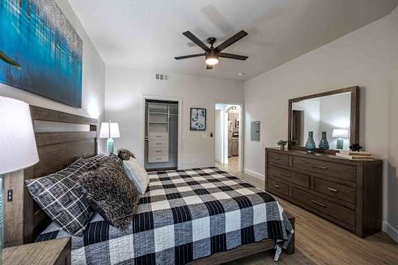 a bedroom with a bed and a ceiling fan