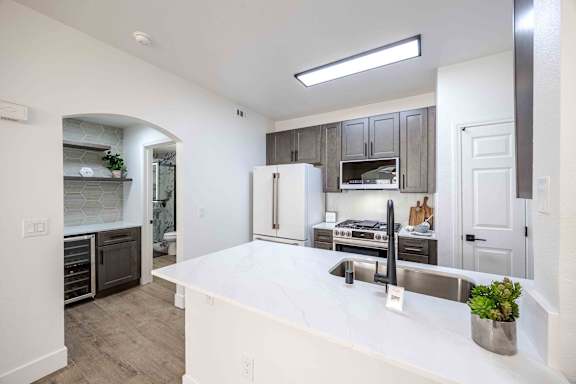 a kitchen with a large white counter top and a sink