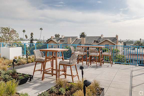 A patio with a table and chairs overlooking a street.