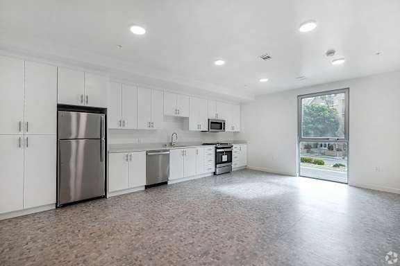 A kitchen with white cabinets and a tiled floor.