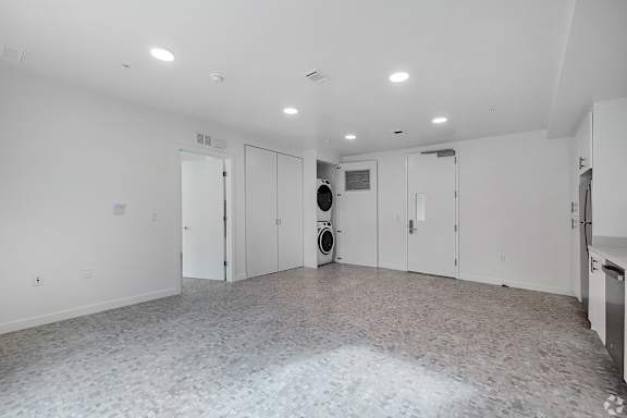 A large empty room with a tiled floor and white walls.
