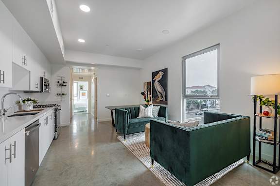 A modern kitchen with white cabinets and a green island.