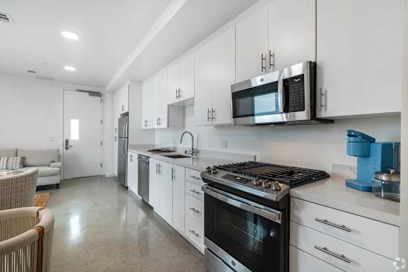 A modern kitchen with white cabinets and stainless steel appliances.