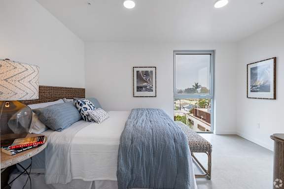A bedroom with a large bed and a view of the outside.