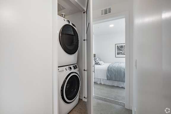 A white laundry room with a washer and dryer in it.