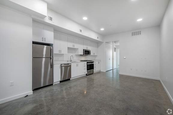 A spacious kitchen with stainless steel appliances and white cabinets.