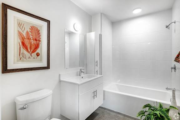 A white bathroom with a white toilet, sink, and bathtub.