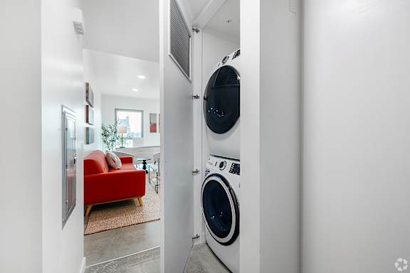 A red couch is in the background of a laundry room.