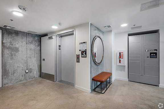 A room with a bench, a mirror, and a fire extinguisher.