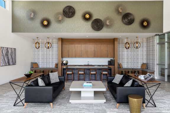A modern living room with a black sofa, a white coffee table, and a wooden cabinet.