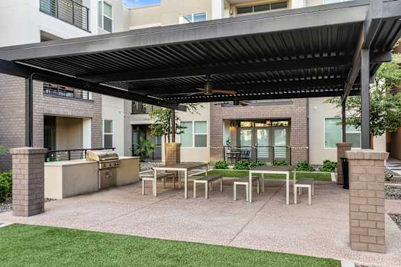 A patio with a table and chairs under a roof.