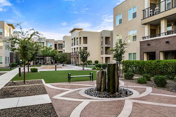 A courtyard with a fountain in the middle of it.