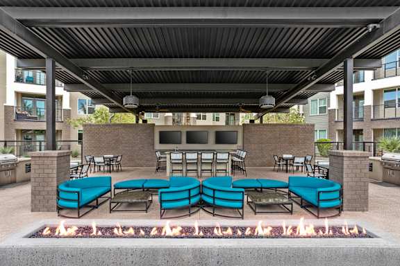 A patio with a fire pit and seating area.