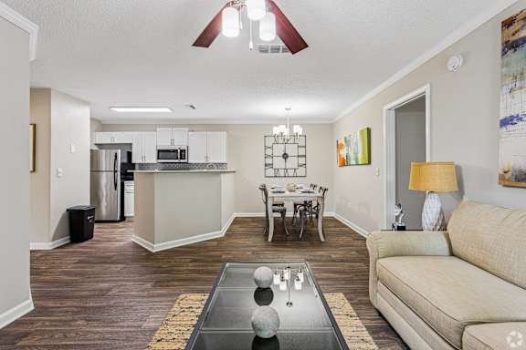 A living room with a couch, a coffee table, and a dining table.