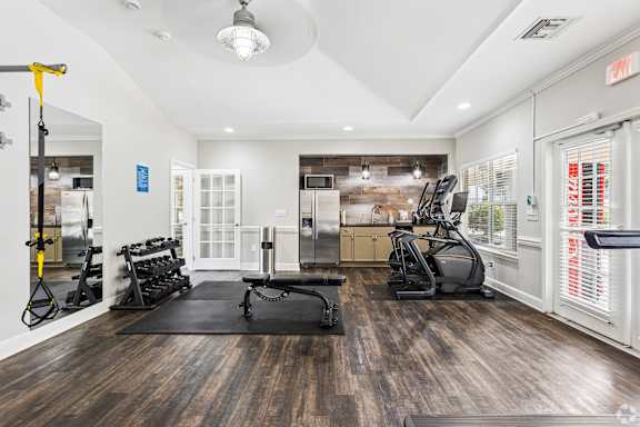 A gym with a variety of equipment including treadmills, weights, and exercise machines.