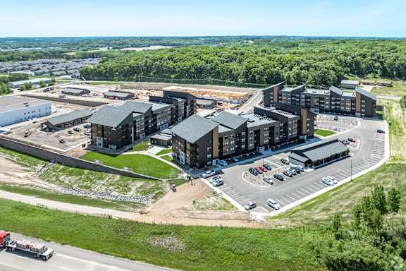 A large building complex with a parking lot in front.