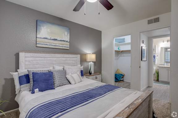 a bedroom with a large bed and a ceiling fan