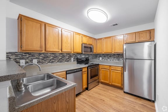 a kitchen with stainless steel appliances and wooden cabinets