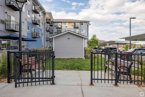 A small house is surrounded by a black fence.