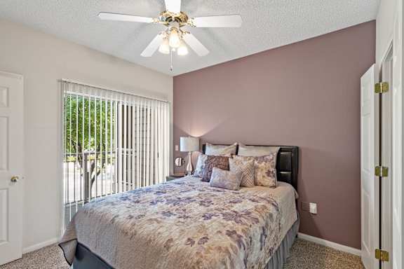 A bedroom with a bed, pillows, and a ceiling fan.