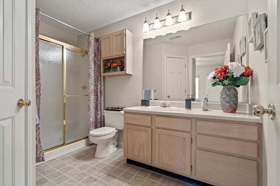 A bathroom with a toilet, sink, and shower.