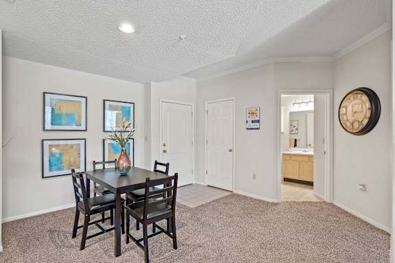 A dining room with a table and chairs.