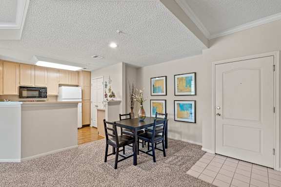 A dining room with a table and chairs.
